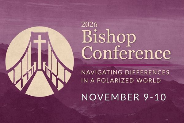 A circular conference logo featuring a stylized suspension bridge leading toward a central cross that forms the bridge's main support tower. The logo is rendered in deep plum and white, with the bridge shown in perspective to symbolize a journey toward Christ and the work of bridging differences.